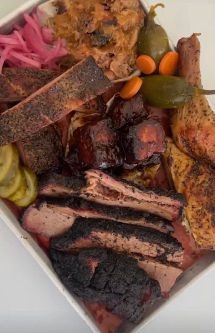 Texas Craft Barbecue Platter with Smoked Meats and Homemade Sides. Slow Cooked Brisket, BBQ Burnt Ends, Smoked Chicken, Juicy Pork Spare Ribs, Pickled Jalapenos