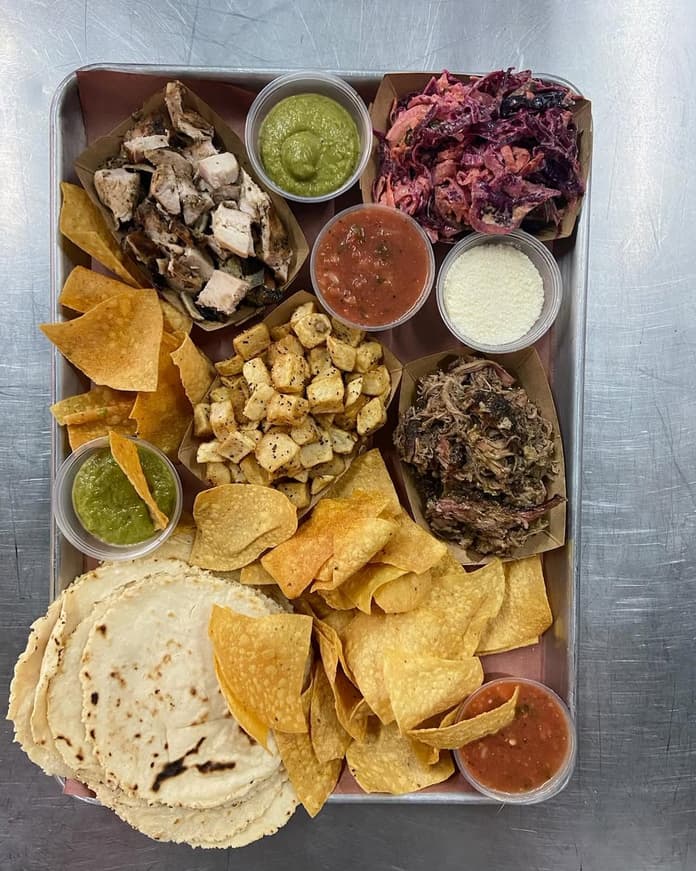 Tex Mex taco platter with homemade tortillas, smoked meats and sides